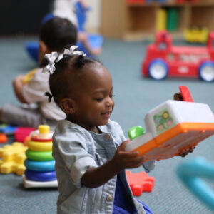 Beautiful black kid playing with toys